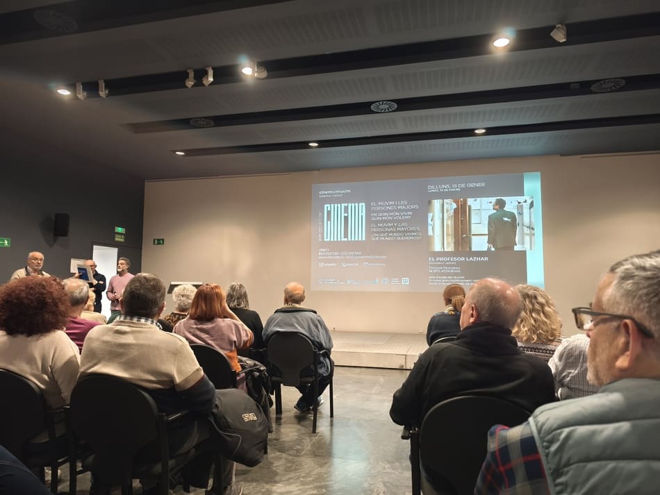 personas sentadas en una sala viendo una película en una pantalla de cine