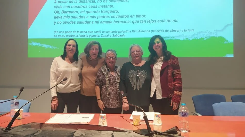 Grupo de mujeres delante de una mesa de auditorio