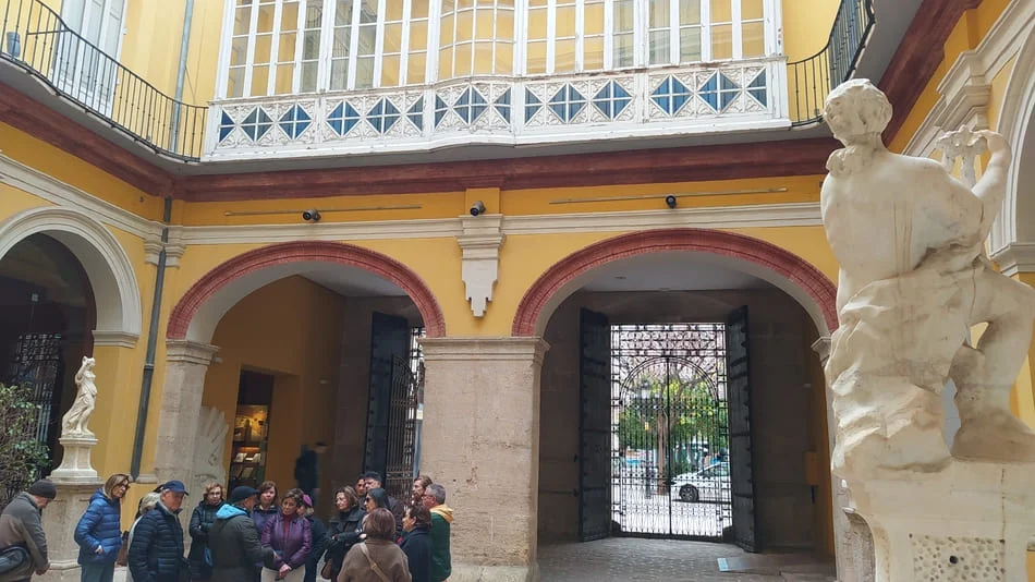 Grupo de personas en patio interior de edificio de época