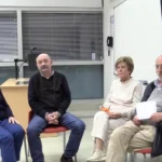 Cuatro personas sentadas en sillas en una sala