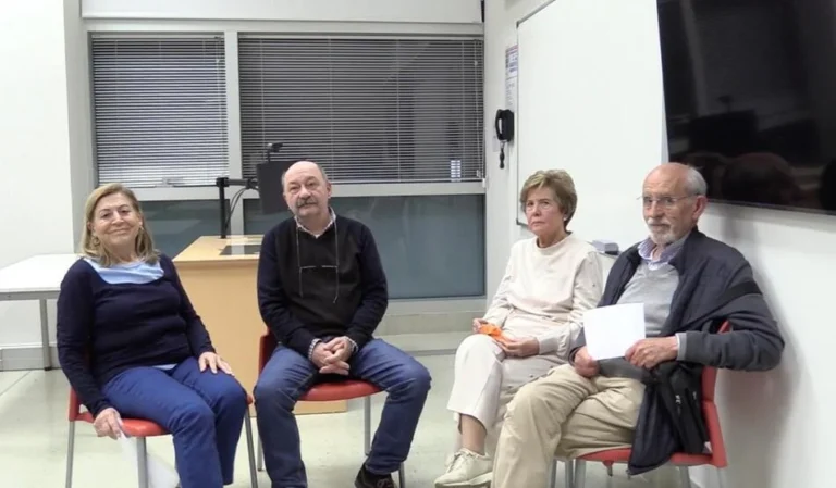 Cuatro personas sentadas en sillas en una sala