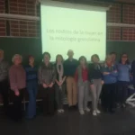 Grupo de personas posando delante de una pantalla de aula