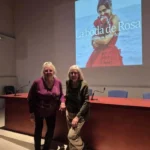 Dos mujeres posando delante de una mesa de conferencia