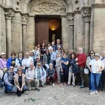 Grupo de personas posando delante de una puerta clásica de iglesia