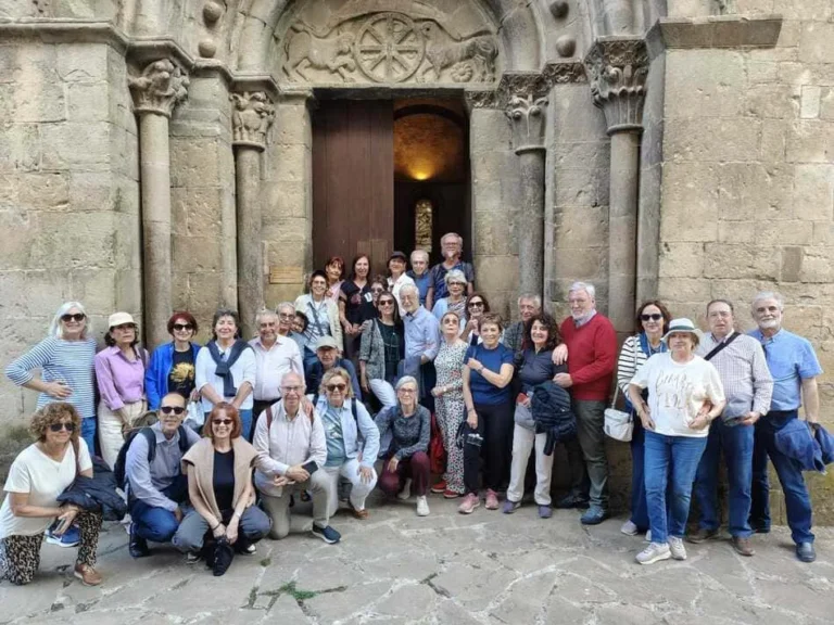 Grupo de personas posando delante de una puerta clásica de iglesia