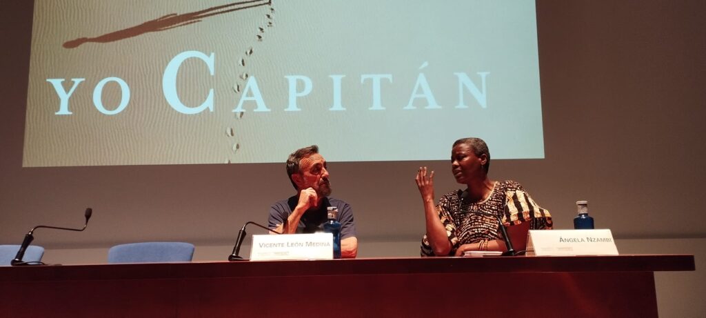 Un hombre y una mujer hablando en una sala de ponencias