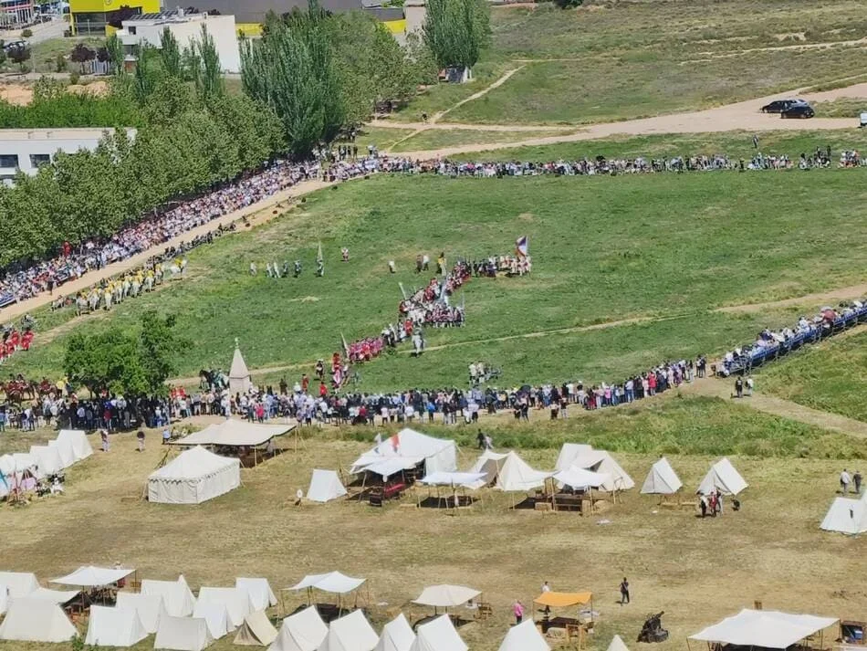 Campo con tropas, tiendas de campaña y público