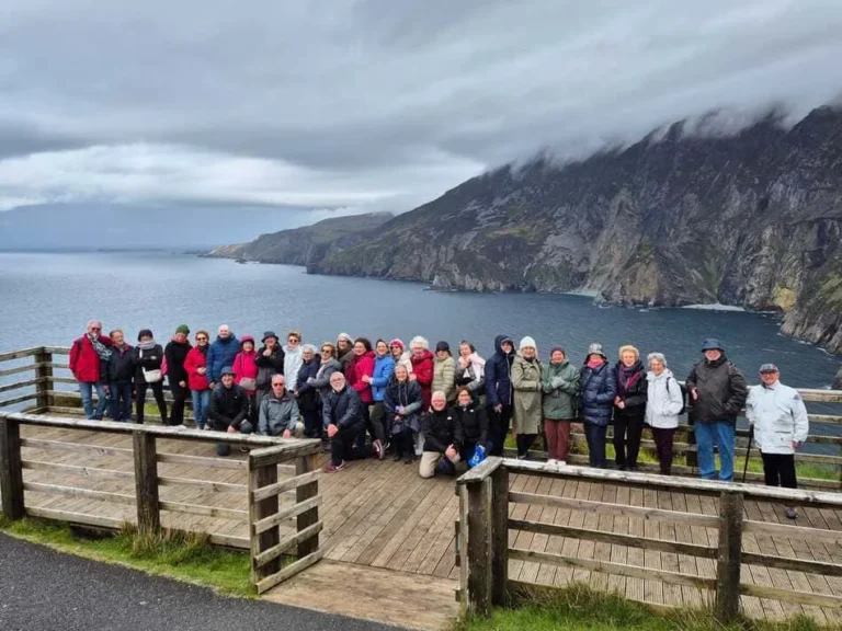 Grupo de personas ante lago y montañas