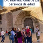 Puerta de catedral con gente mayor delante y cartel de letras azules