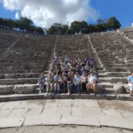 Ruinas de teatro antiguo con personas sentadas